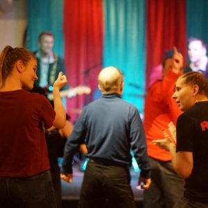 Yleisö tanssii bändin soittaessa taustalla.