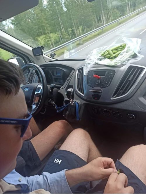 Nuori mies syö herneitä autossa.