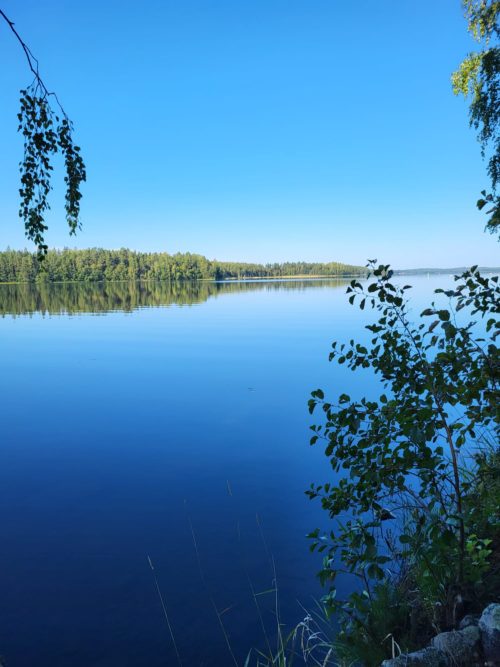 Tyyni järvi ja sininen taivas.