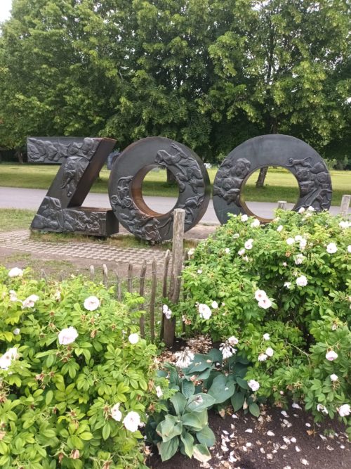 Zoo-patsas, jonka ympärillä on puita ja kukkia
