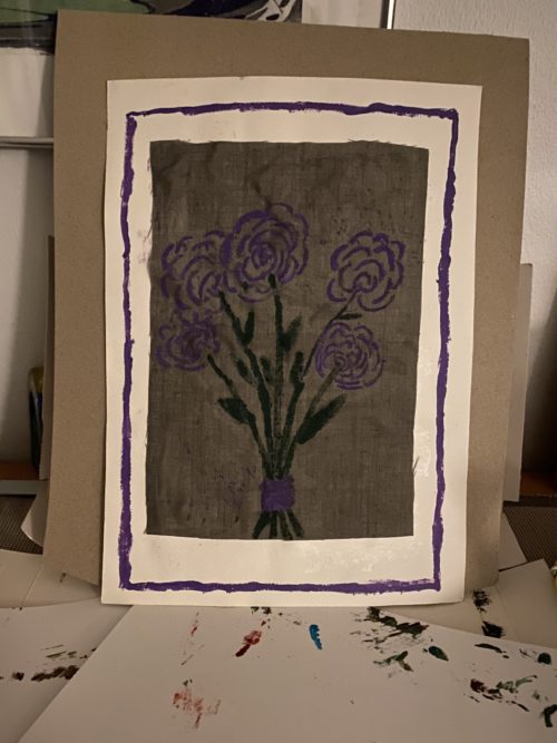 Kortissa kukkakimppu, jossa violetteja kukkia.