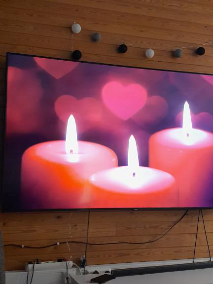 Television näytöllä kynttilöitä ja sydämiä.