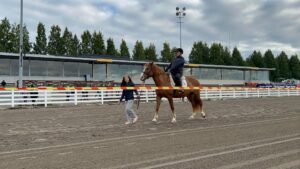 Mies ratsastaa hevosella.