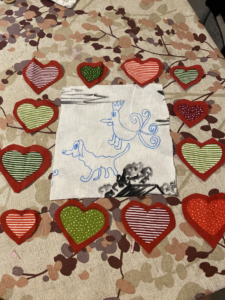 Kankaisia sydämiä, joiden keskellä on kuva eläimestä ja linnusta.