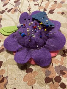 Huopakankaasta tehty neulatyyny, jossa on neuloja.