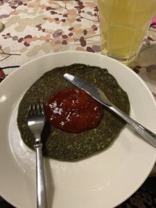 Lautasella pinaattilettu ja puolukkahilloa.