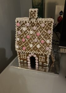 Piparitalo, jossa on koristeena vaaleanpunaisia ja valkoisia suklaakarkkeja.