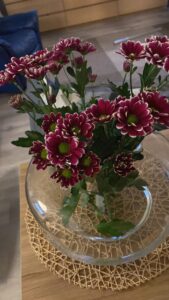 Kimppu punaisia kukkia pöydällä.