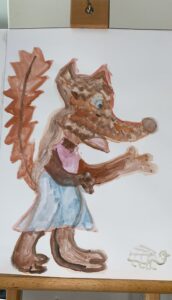 Ruskea kettu, jolla vaaleanpunainen paita ja siniset housut.