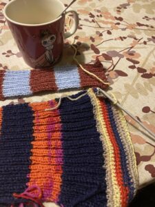 kahvikuppi ja kaksi raidallista neulosta.