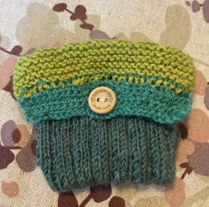 Neulottu pussukka, jossa on vihreän eri sävyjä.