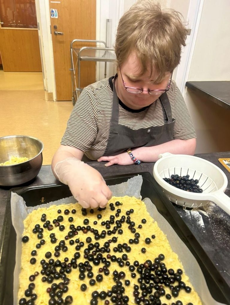 Nainen leipoo mustikkapiirakkaa.