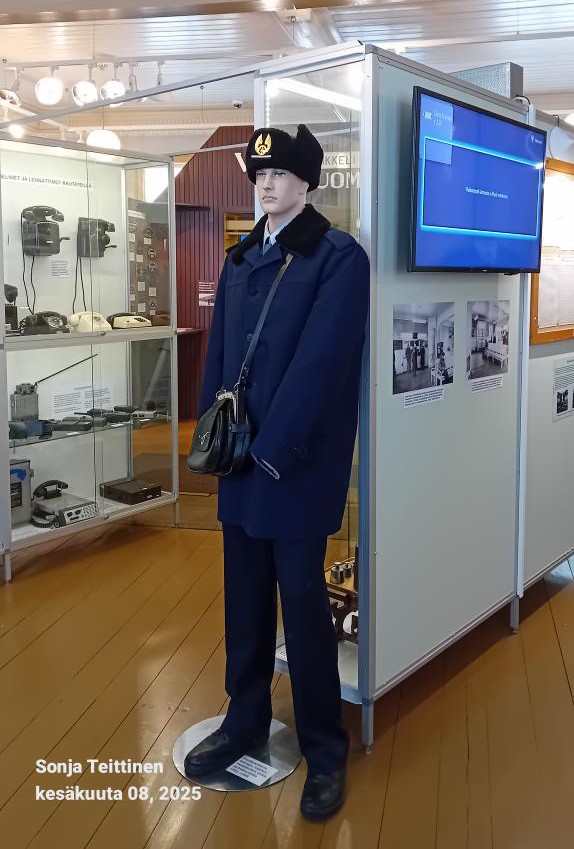 Museossa nukke, jonka päällä on vanhat siniset vaatteet.